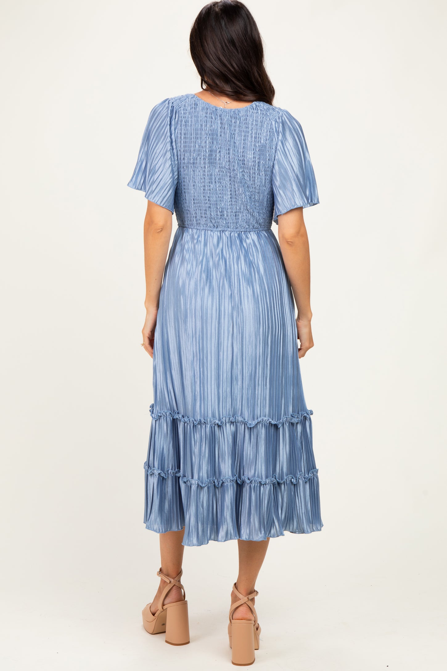 woman wearing a light blue midi dress with short sleeves and tiered ruffles, view of the back