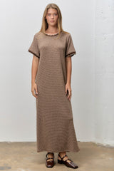 woman wearing a brown striped maxi dress with scalloped sleeves and a relaxed fit