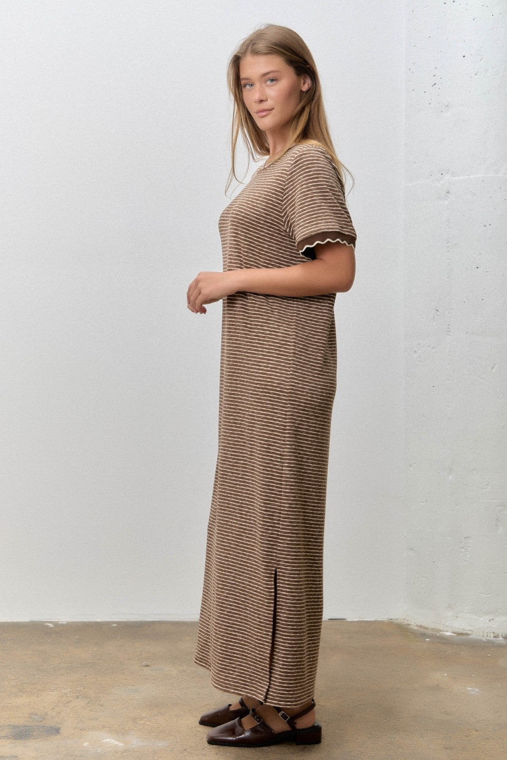 woman wearing a brown and cream striped maxi dress with short sleeves and side slits