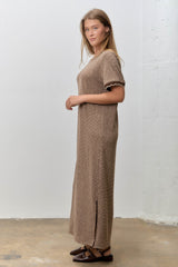 woman wearing a brown and cream striped maxi dress with short sleeves and side slits