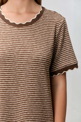woman wearing a brown striped t-shirt with a scalloped neckline and sleeve hem