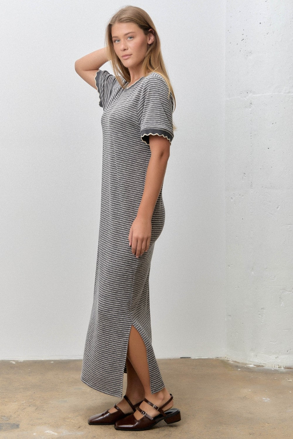 woman wearing a black and white striped maxi dress with short sleeves and side slits