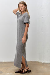 woman wearing a black and white striped maxi dress with short sleeves and side slits