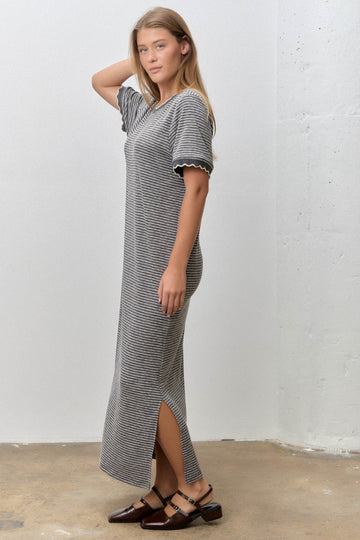 woman wearing a black and white striped maxi dress with short sleeves and side slits