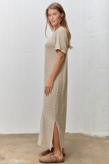 woman wearing a beige striped short sleeve maxi dress with side slits and brown sandals
