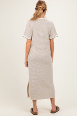woman wearing a beige and brown striped maternity dress with short sleeves and a side slit