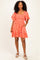woman wearing an orange short sleeve floral embroidered dress with a square neckline and pockets