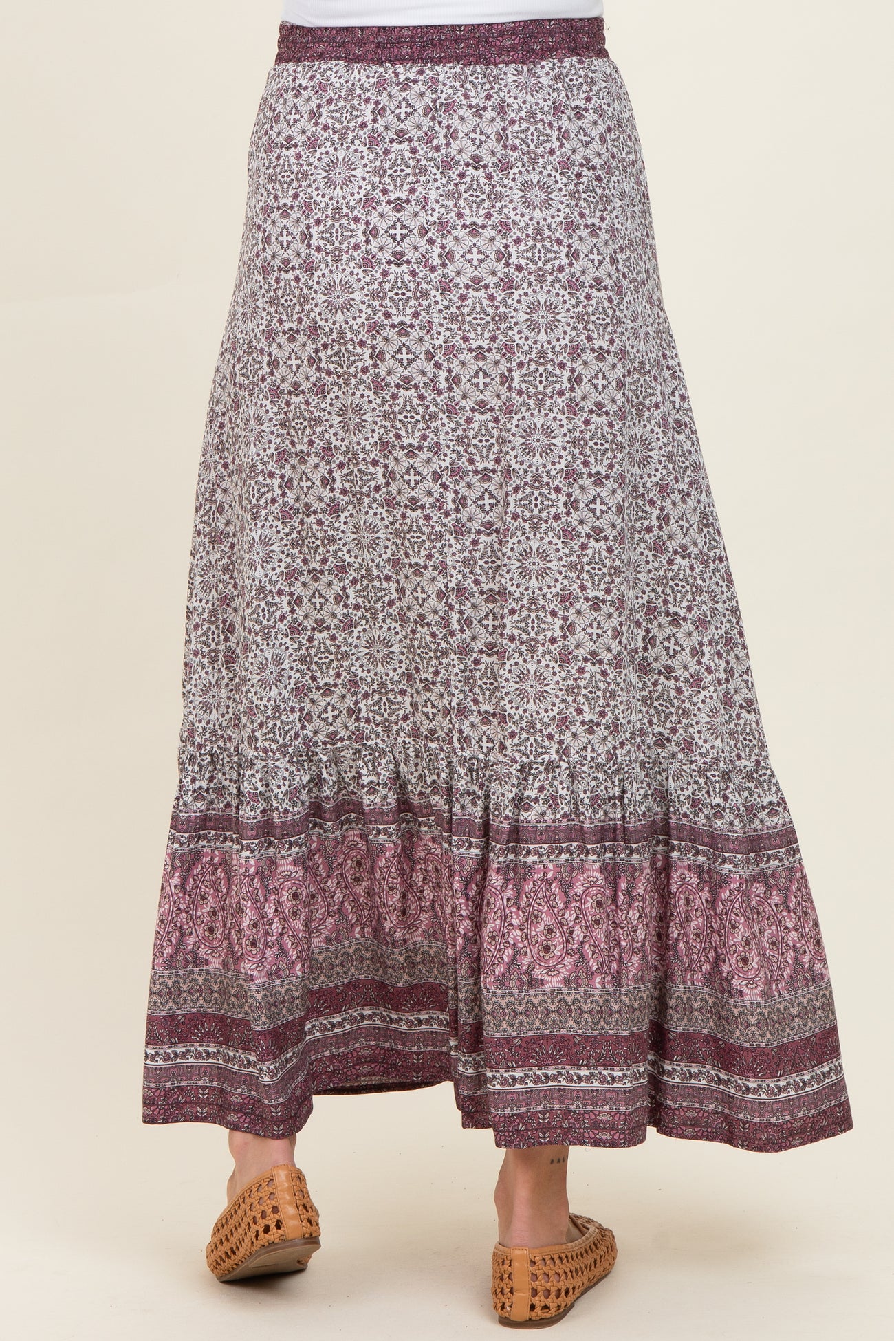 woman wearing a patterned maxi maternity skirt with a tiered hem and comfortable elastic waistband