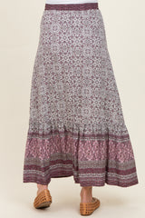 woman wearing a patterned maxi maternity skirt with a tiered hem and comfortable elastic waistband