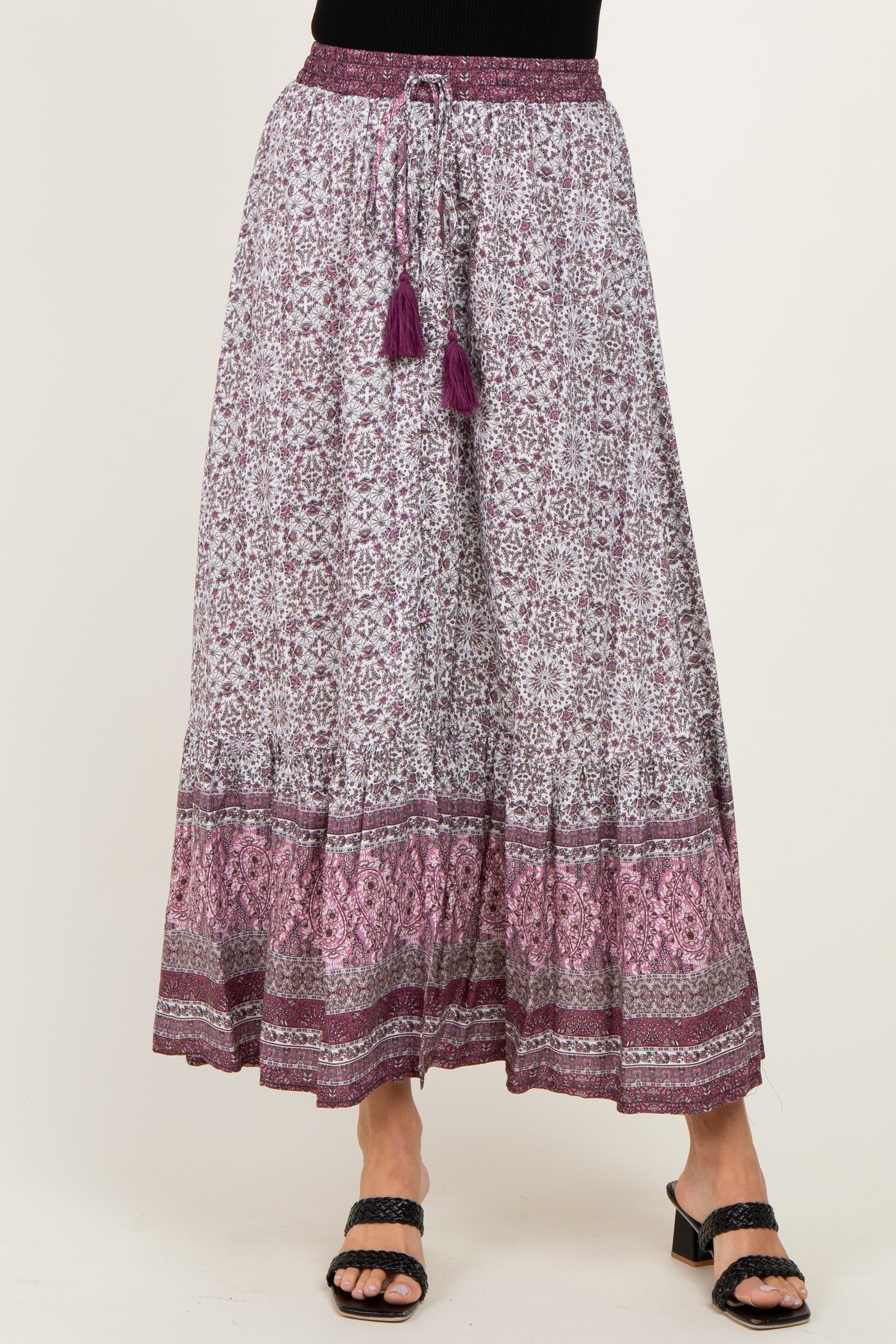 woman wearing a purple and white patterned maxi skirt with tassel drawstring and layered hemline