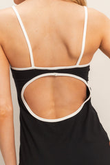 woman wearing a black tank top with a white trimmed open back detail