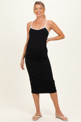 woman wearing a black maternity midi dress with white trim and a visible baby bump