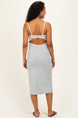 woman wearing a gray maternity dress with a cutout back detail and adjustable straps