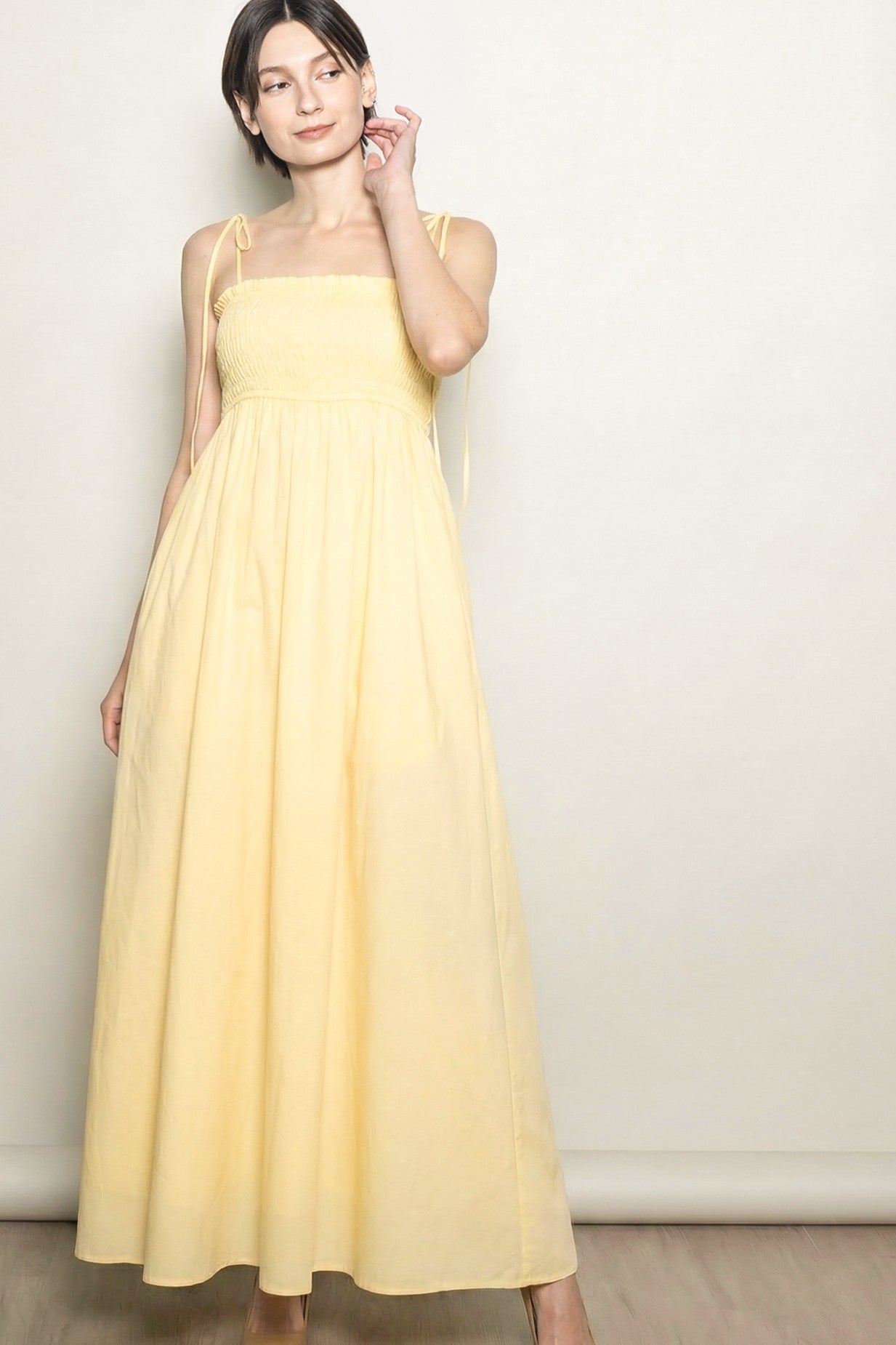 woman wearing a yellow maxi dress with a smocked bodice and adjustable straps