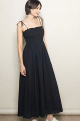 woman wearing a black maxi dress with smocked bodice and thin adjustable straps