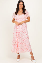 woman wearing a pink floral maxi dress with short sleeves and a fitted bodice