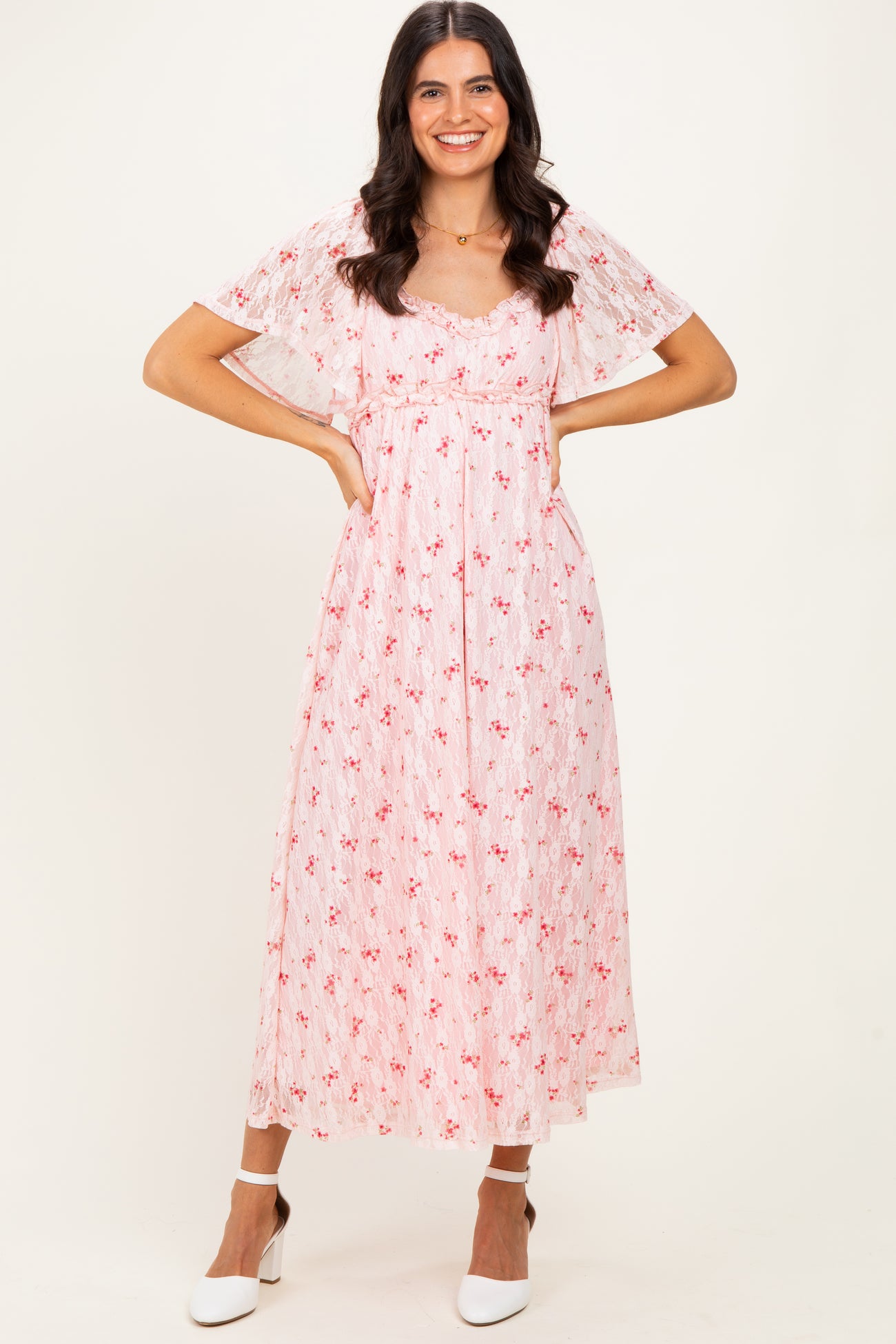 woman wearing a pink floral maxi dress with flutter sleeves and a fitted waist