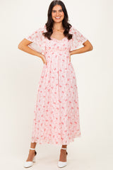 woman wearing a pink floral maxi dress with flutter sleeves and a fitted waist