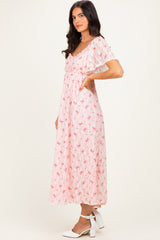 woman wearing a pink floral midi dress with short sleeves and ruffles