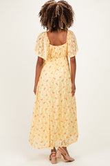 woman wearing a yellow floral maternity dress with flutter sleeves and a flowing skirt, showing a baby bump from behind