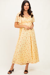 woman wearing a yellow floral maxi dress with short sleeves and a scoop neckline