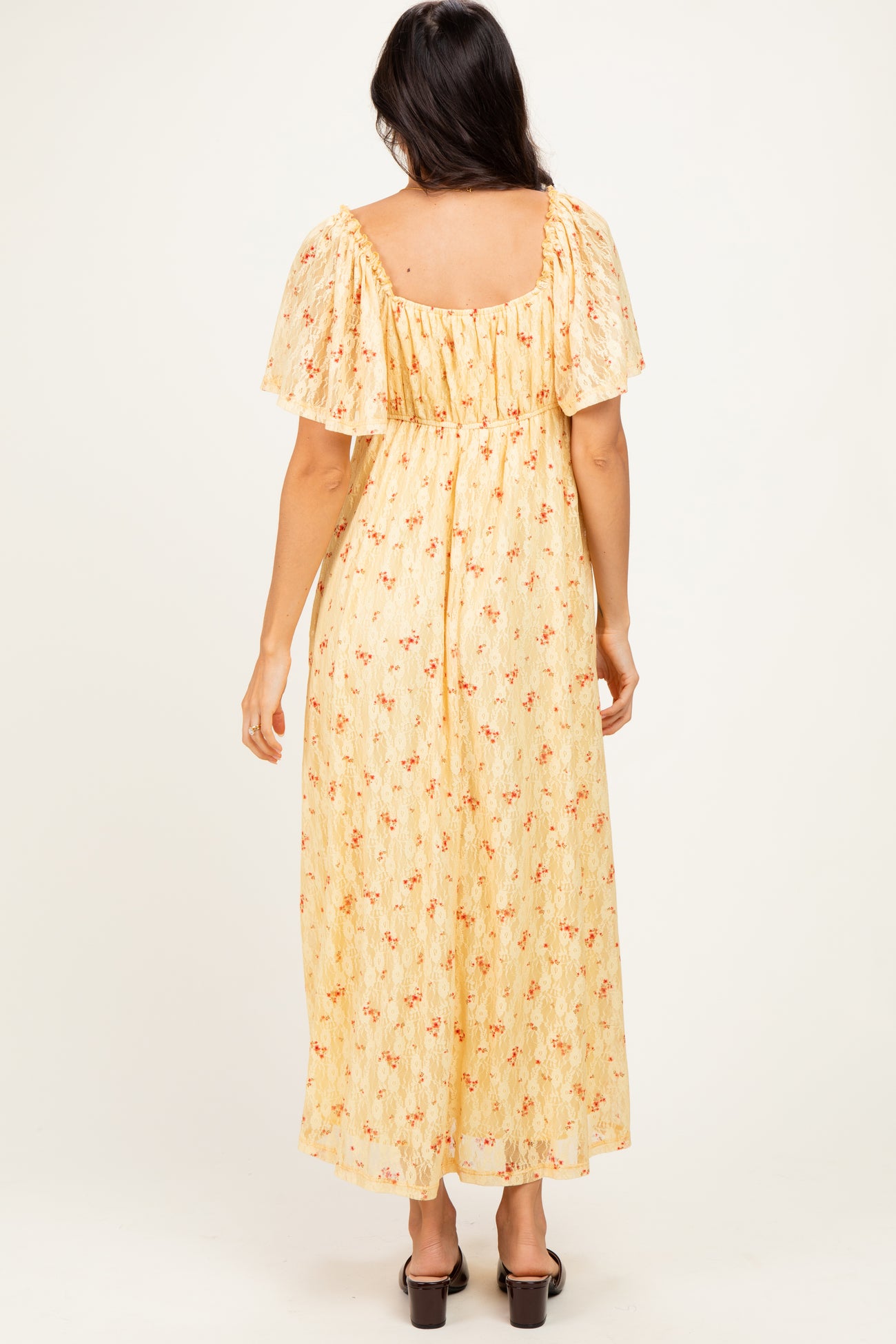 woman wearing a yellow floral maxi dress with flutter sleeves, viewed from the back