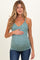 woman wearing a teal maternity tank top with white floral print and holding her baby bump