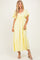 woman wearing a yellow maxi dress with flutter sleeves and a tie detail at the bust
