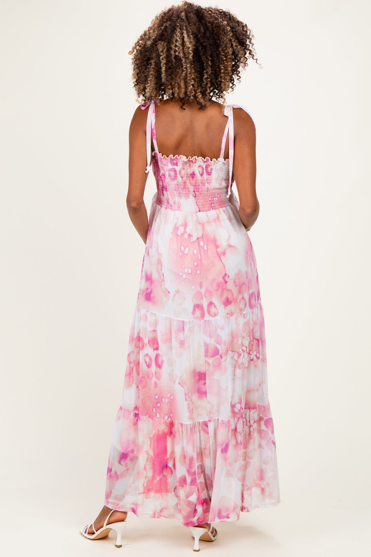 woman wearing a pink and white tie-dye maternity maxi dress with a smocked back and adjustable straps