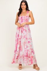 woman wearing a pink and white floral maxi dress with a smocked bodice and tiered skirt