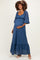 woman wearing a dark blue lace maternity maxi dress with puff sleeves and a baby bump visible