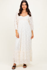 woman wearing a cream lace maxi dress with long sleeves and a tiered hemline