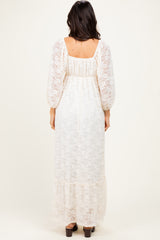 woman wearing a cream lace maxi dress with puff sleeves and a tiered hem, viewed from the back