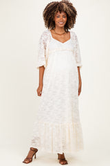 woman wearing a cream lace maternity maxi dress with short sleeves and a visible baby bump