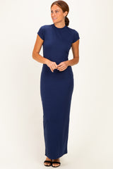 woman wearing a navy blue cap sleeve maxi dress standing with hands clasped at the waist