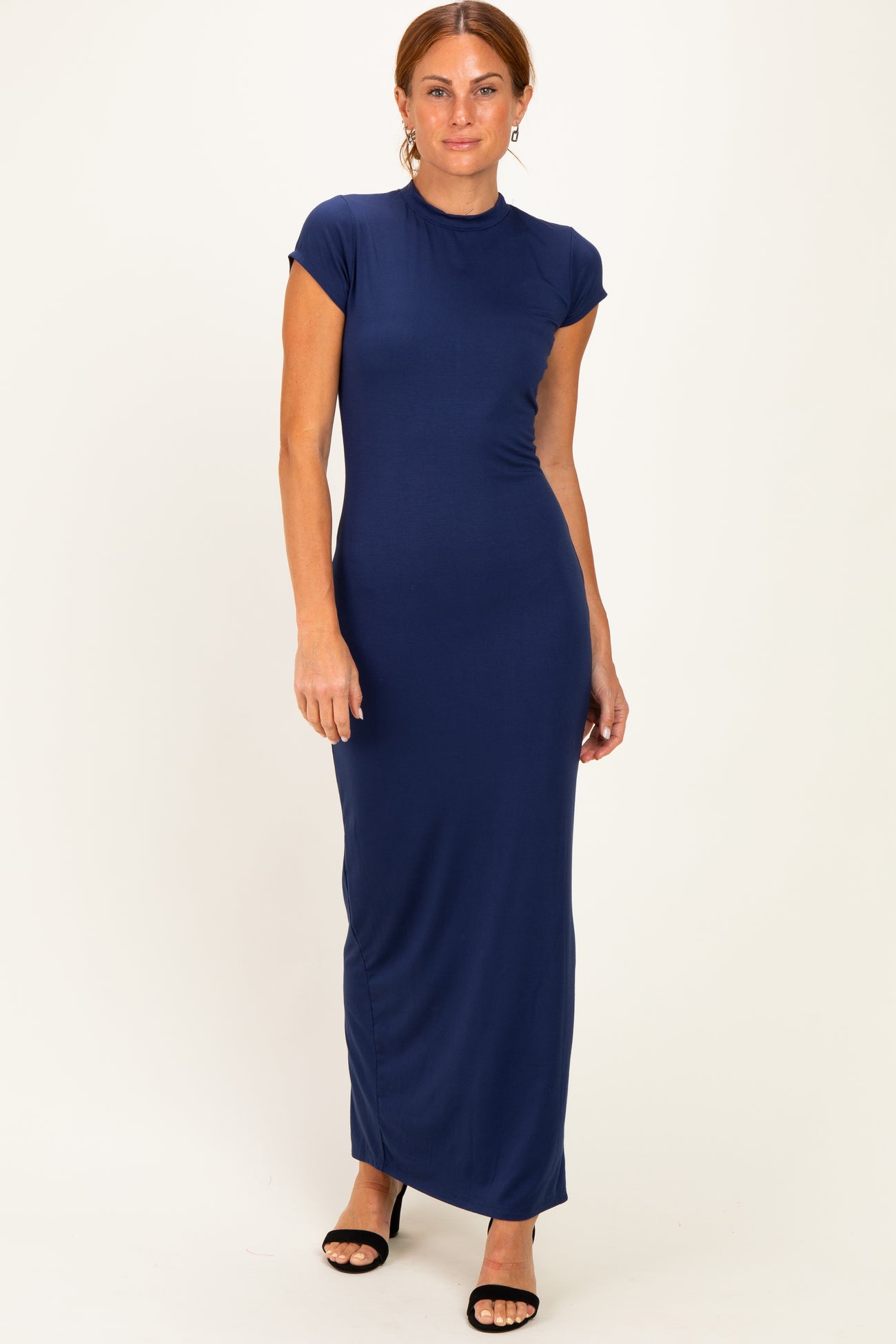 woman wearing a navy blue cap sleeve maxi dress with a fitted silhouette and side slit