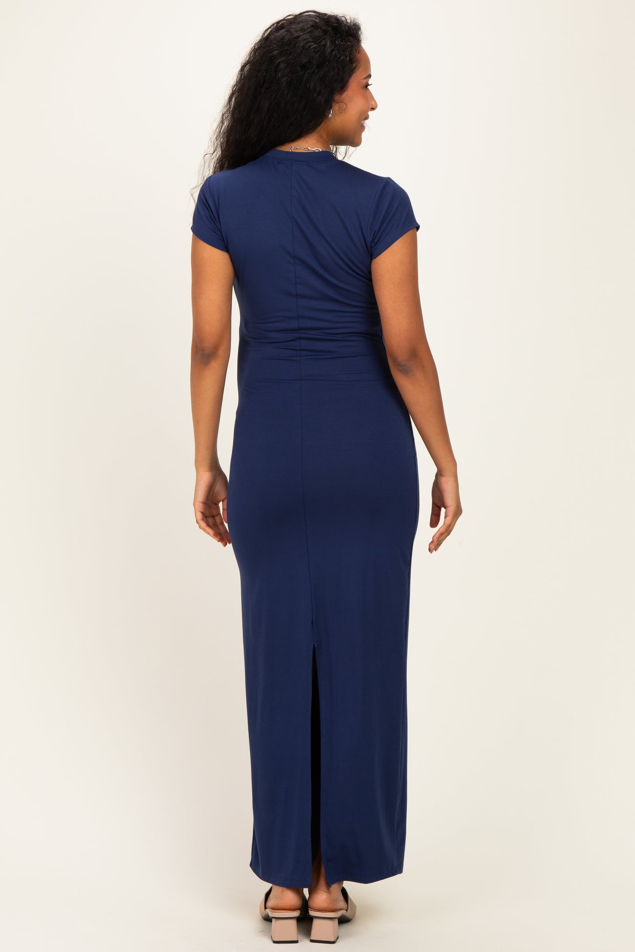 woman wearing a navy blue maternity maxi dress with short sleeves and a back slit