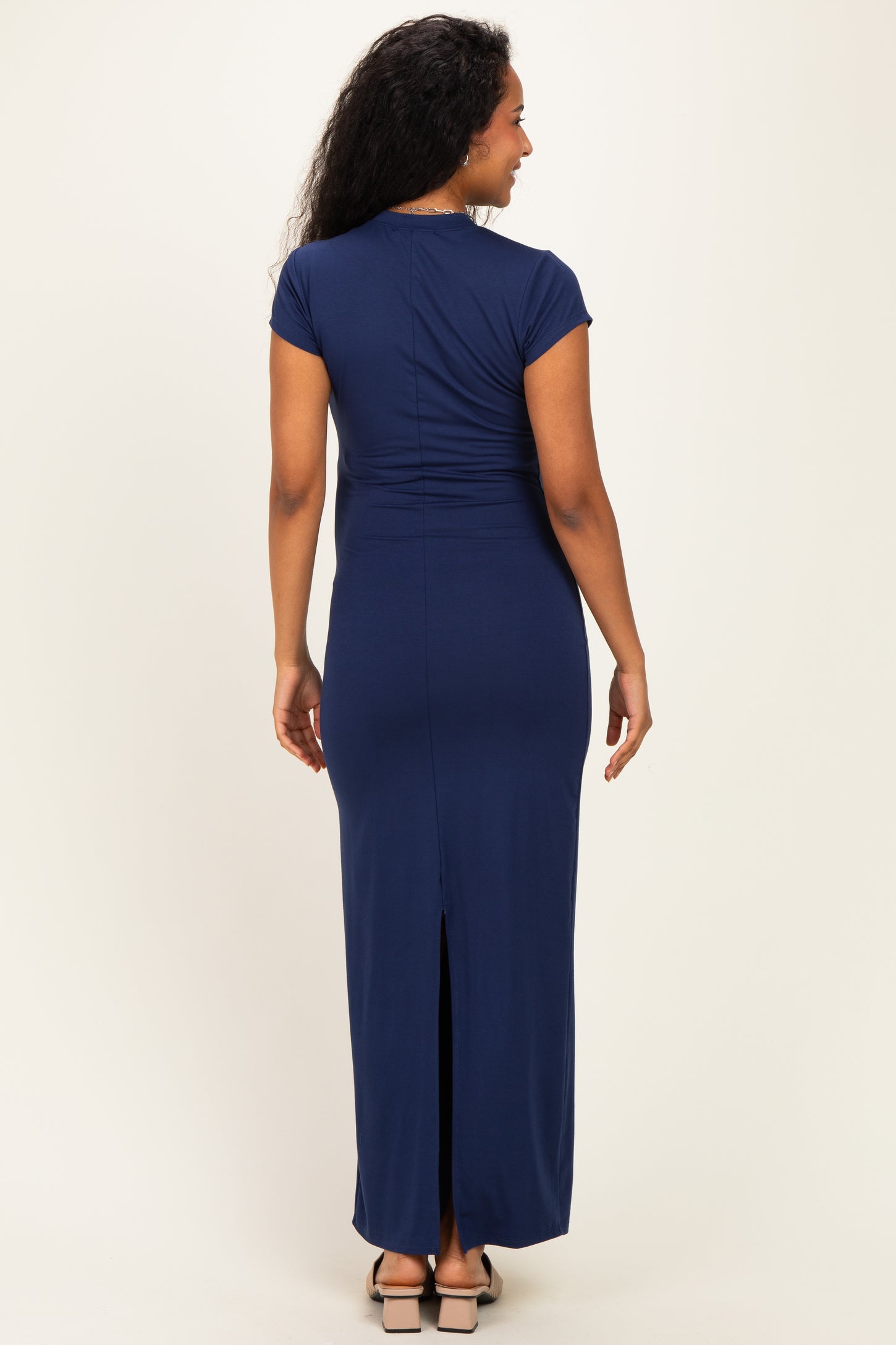 woman wearing a navy blue maternity maxi dress with short sleeves and a back slit