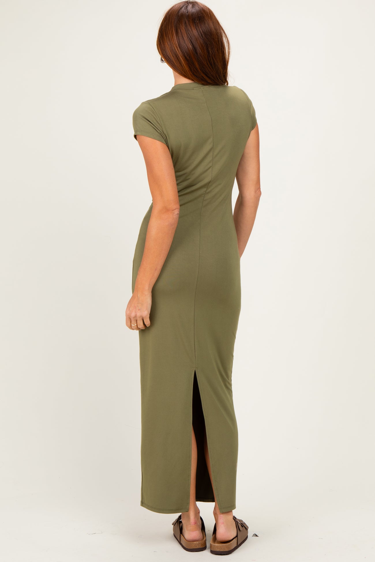 woman wearing a fitted olive green maxi dress with short sleeves and a side slit, viewed from the back