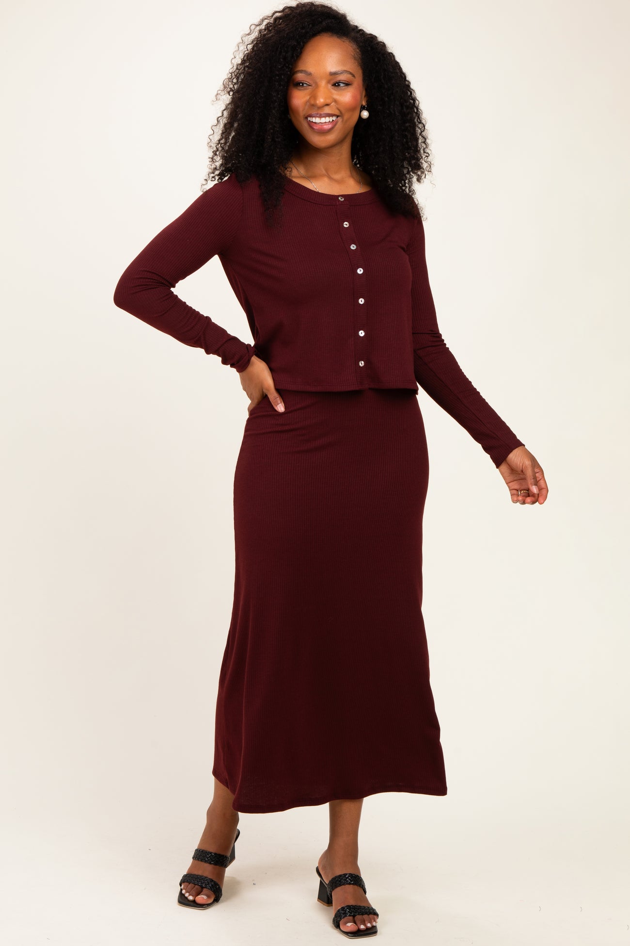 woman wearing a burgundy ribbed two-piece set with a long skirt and button-up crop top