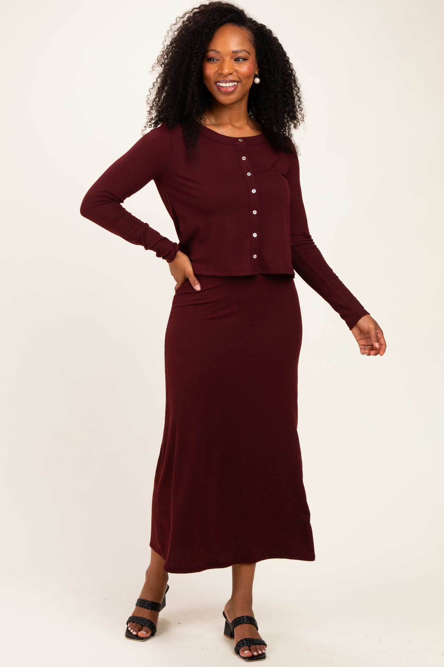 woman wearing a burgundy ribbed two-piece set with a long skirt and button-up crop top
