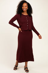 woman wearing a burgundy ribbed two-piece set with a long skirt and button-up crop top