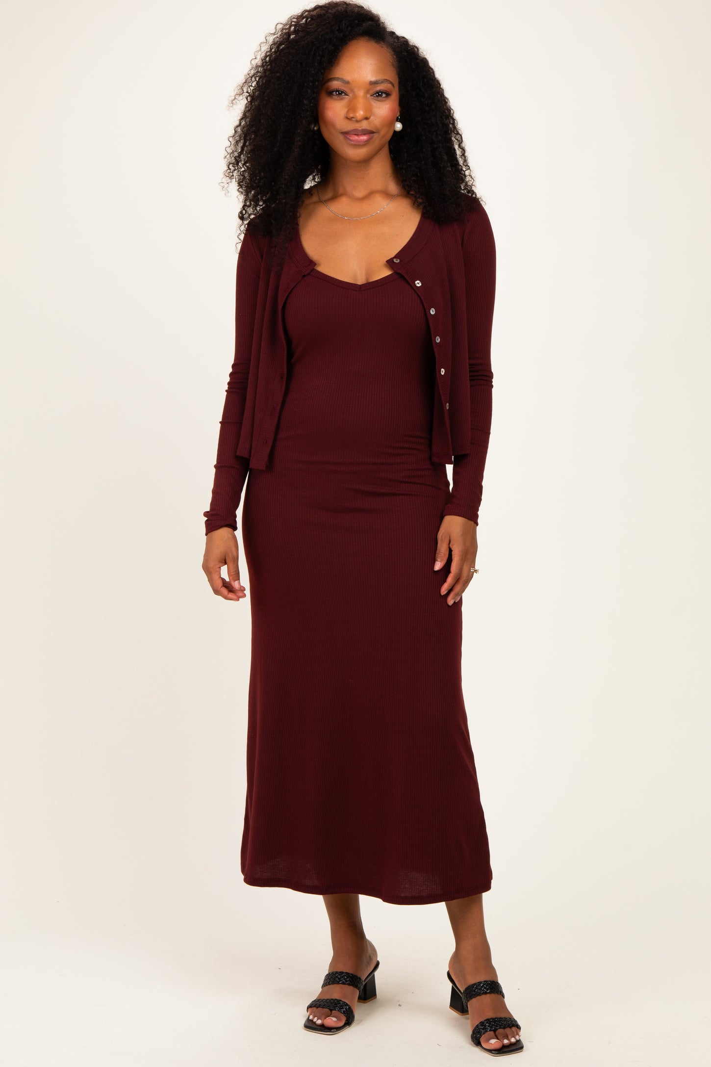 woman wearing a burgundy ribbed maxi dress with a matching cardigan and black heeled sandals