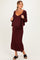 woman wearing a burgundy maternity maxi dress and matching cardigan, showing her baby bump with casual black sandals