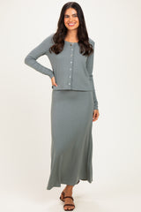 woman wearing a light green ribbed long sleeve button-up top and matching maxi skirt with a fitted silhouette