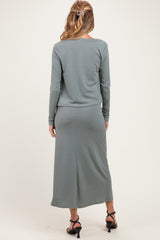 woman wearing a long sleeve gray ribbed maternity dress with a fitted skirt and styled hair