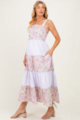 woman wearing a floral and striped maternity maxi dress with pockets and showing her baby bump