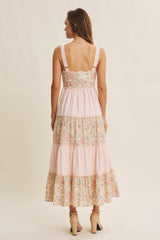woman wearing a pink floral tiered maxi dress with adjustable straps, viewed from the back