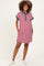 woman wearing a red and white striped maternity polo dress with navy collar and pockets, showcasing her baby bump