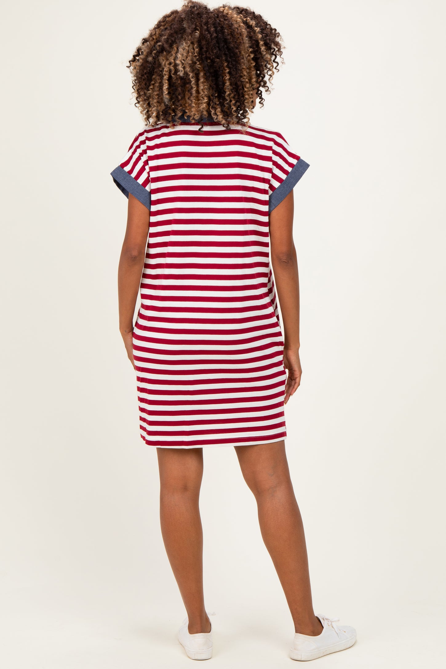 woman wearing a red and white striped maternity dress with navy blue accents, showing a stylish and comfortable back view